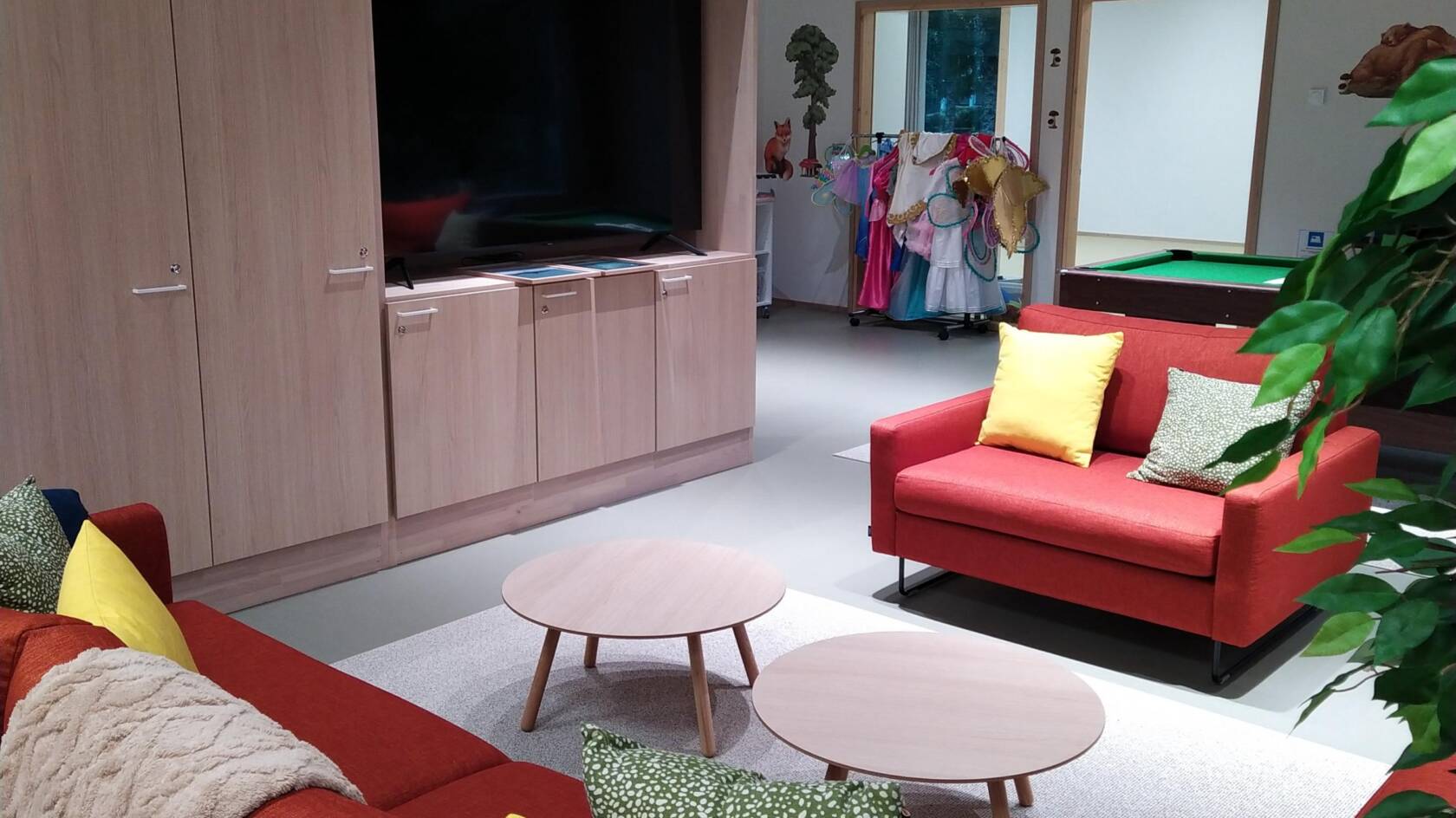 Oranssit sohvat, tv ja biljardipöytä